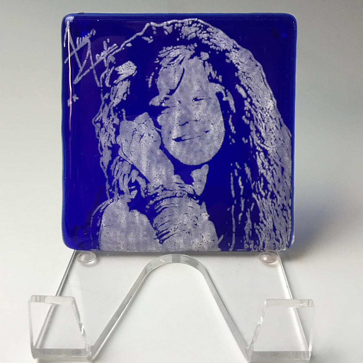 a blue glass plaque with a picture of a woman on it