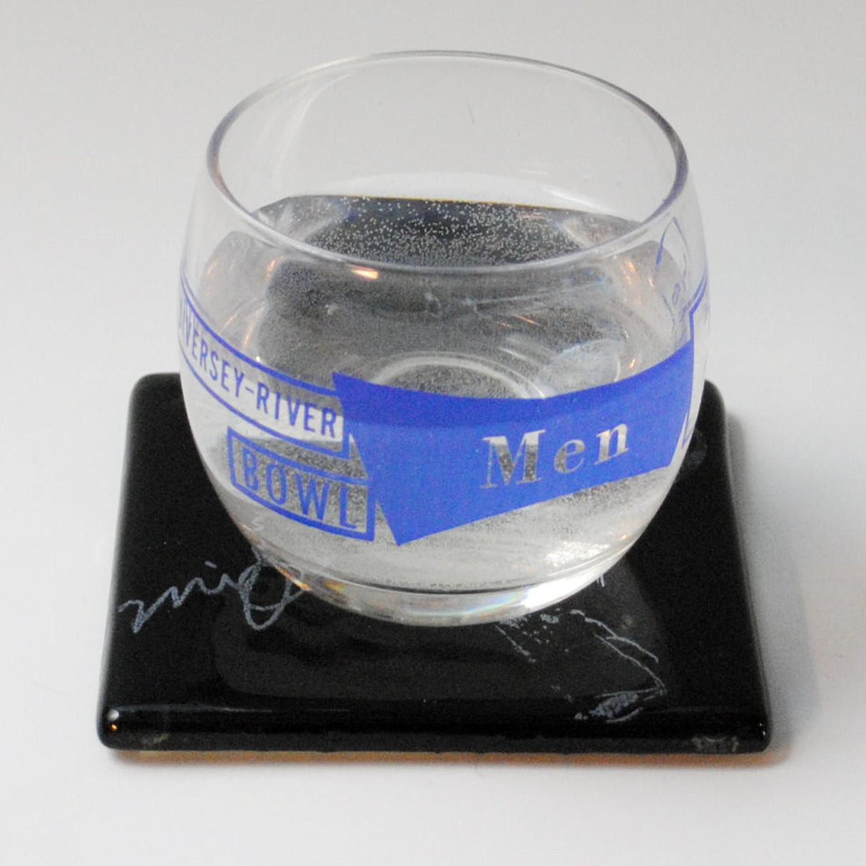 a glass of water sitting on a coaster