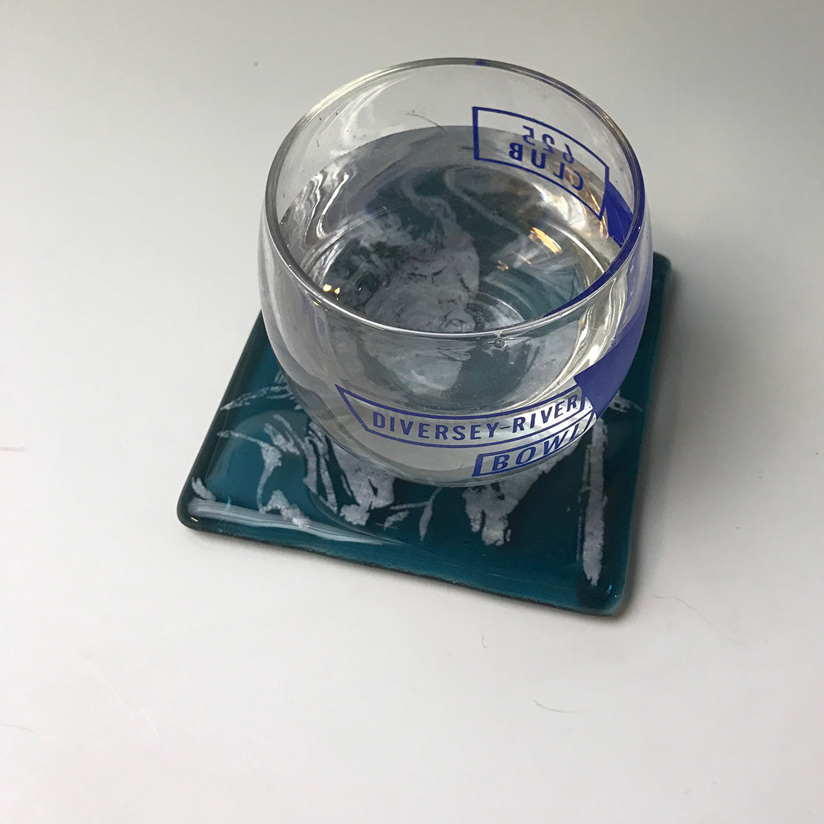 a glass of water sitting on top of a blue tray