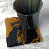 a metal cup sitting on top of a coaster