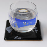 a glass of water sitting on top of a coaster