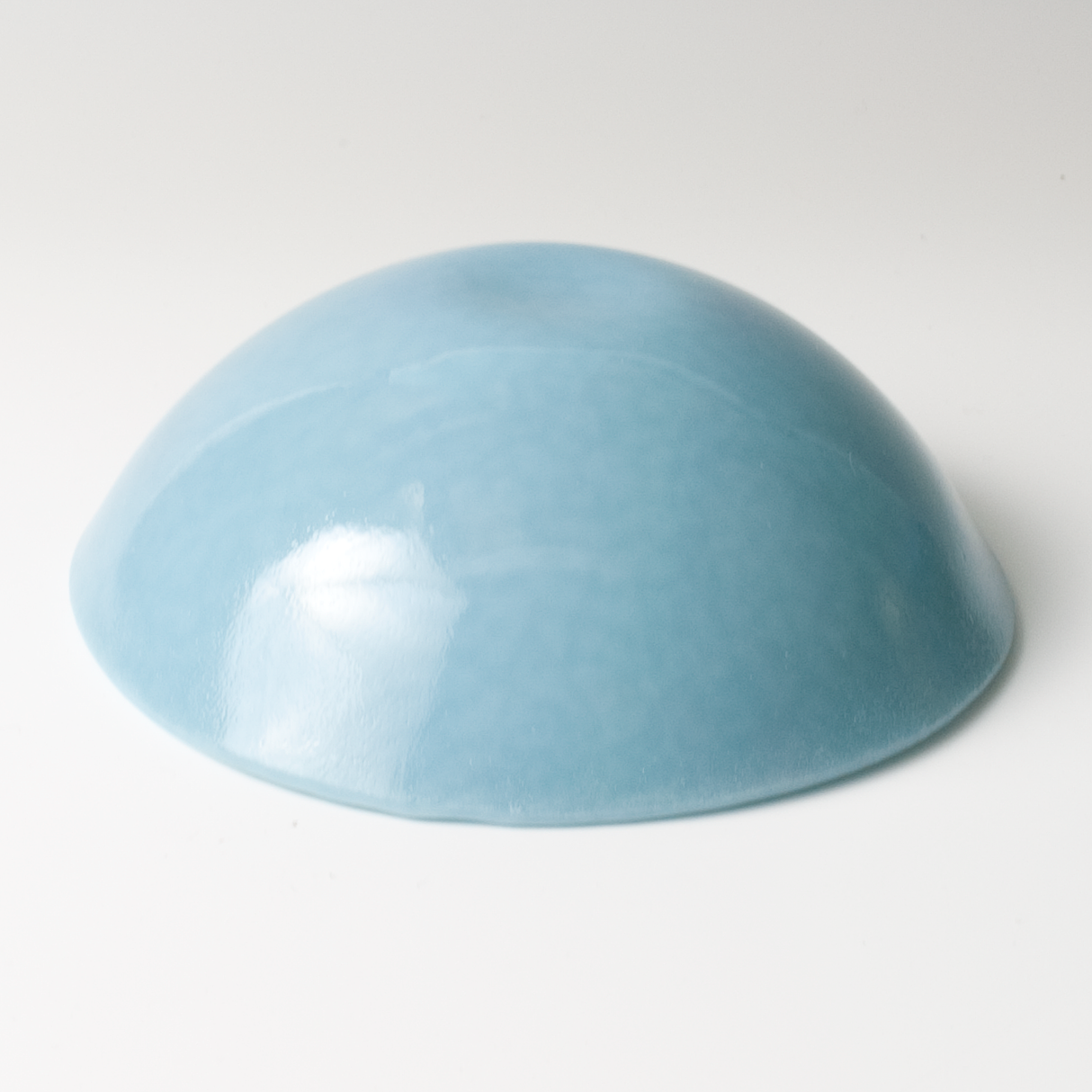 a light blue bowl sitting on top of a white table