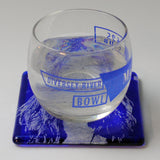 a glass of water sitting on top of a blue coaster