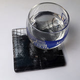a glass of water sitting on top of a coaster