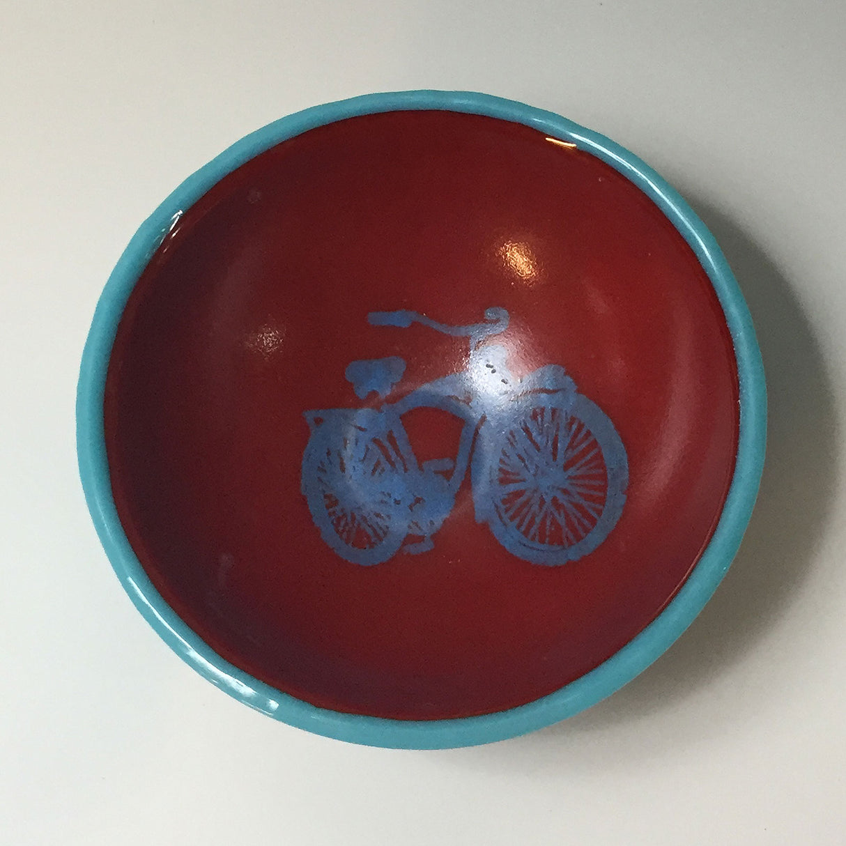 a red and blue bowl with a bicycle on it