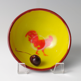 a yellow bowl with a red rooster painted on it