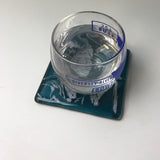 a glass of water sitting on top of a blue tray