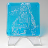 a glass block with a drawing of a woman playing a guitar